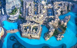 Top-down cityscape view of Downtown Dubai with vibrant pool reflections