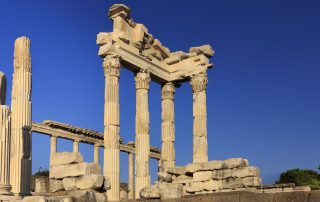Ancient stone columns of the Acropolis ruins against clear blue sky