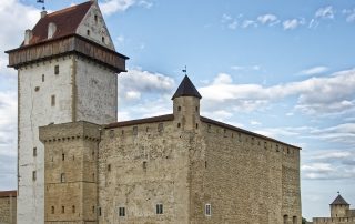 Medieval stone tower and fortress walls under bright skies in Estonia