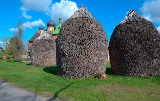 Traditional Estonian haystacks arranged in rows under blue skies