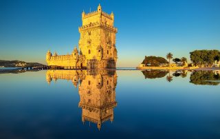 Belem Tower in Lisbon at golden hour – historic fortress glowing against reflective water