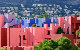 Colorful pink and red buildings of La Muralla Roja, Spain – bold geometric apartment complex with mountain views