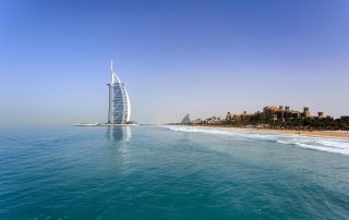 Burj Al Arab rising above turquoise waters with private beach in foreground