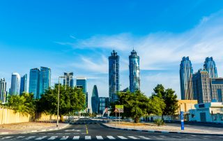 Towers and palm trees along Dubai road on a clear sunny day