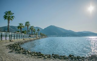 Calm turquoise bay with palm trees and mountains along Turkish coast