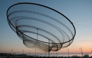 Futuristic spiral sculpture under soft dusk sky – modern outdoor installation in public space