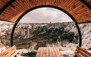 Terrace view overlooking historic stone buildings in Cappadocia through archway