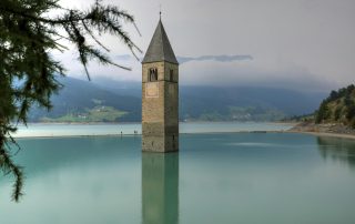 Submerged bell tower in Reschensee, South Tyrol – haunting symbol of Italian alpine history.