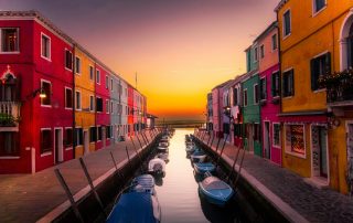 Colorful canal-side houses at sunset in a peaceful Italian townscape
