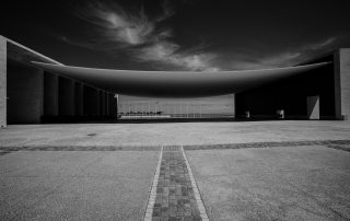 Black and white minimalist photo of an empty asphalt lot – modern symmetry and urban texture