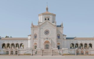 Elegant white cathedral with domed roof and ornate carvings in European plaza