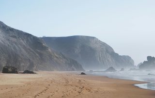 Remote Portuguese beach with misty cliffs in the background – peaceful and atmospheric